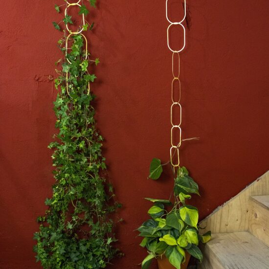modern design geometrisch messingplantensteun voor klimplanten tegen muur en plafond rood met houten trapgolden color brass indoors outdoors