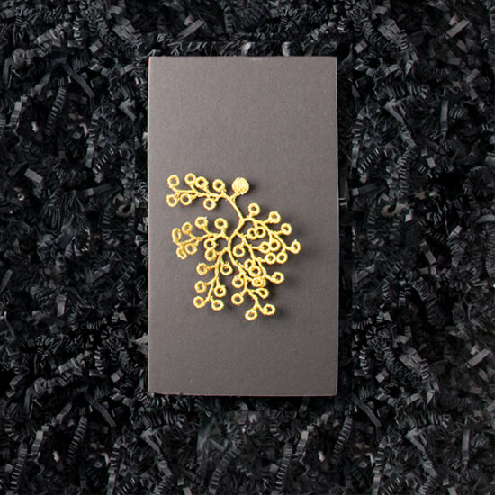 Embroidered golden brooch inspired by spikemoss