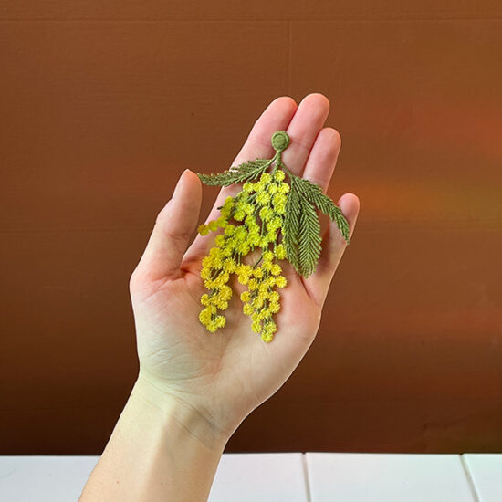 Mimosa flowers embroidered brooch holding in hand